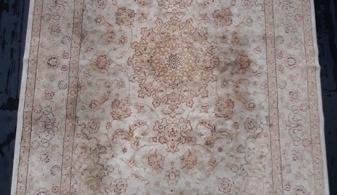 Close-up view of a prayer rug before cleaning